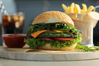 Photo of Tasty vegetarian burger served with french fries and soda drink on white table, closeup