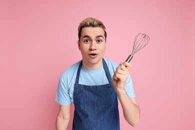 Photo of Portrait of emotional confectioner holding whisk on pink background