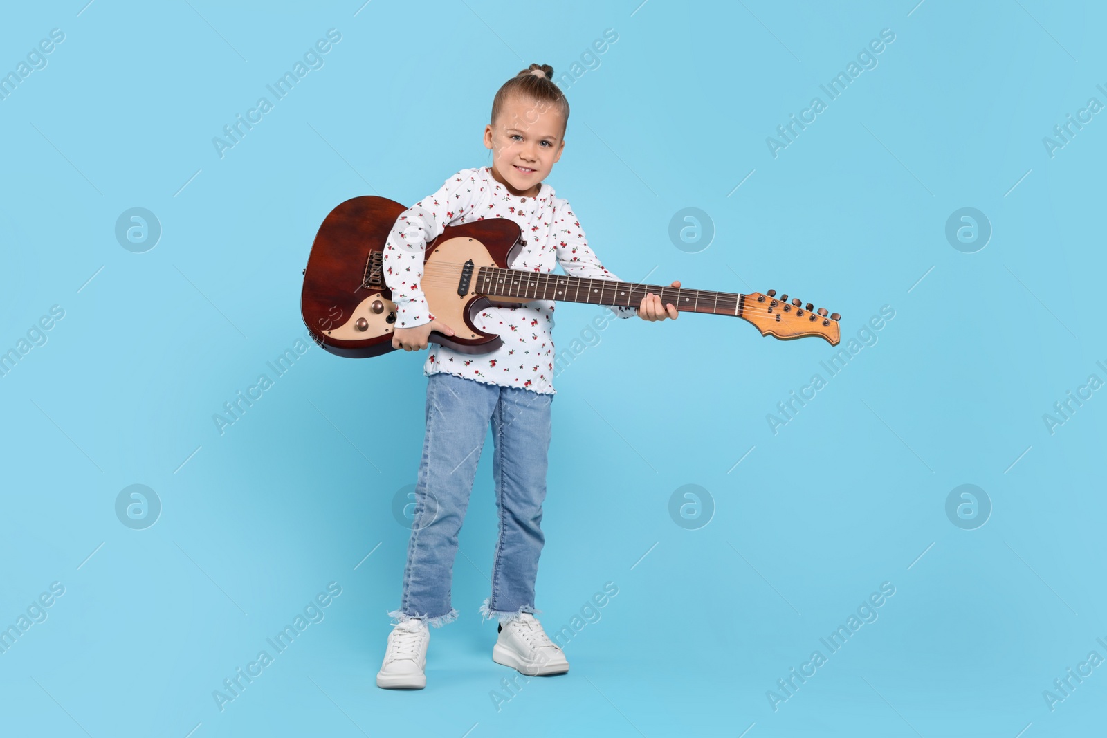 Photo of Happy girl with electric guitar on turquoise background