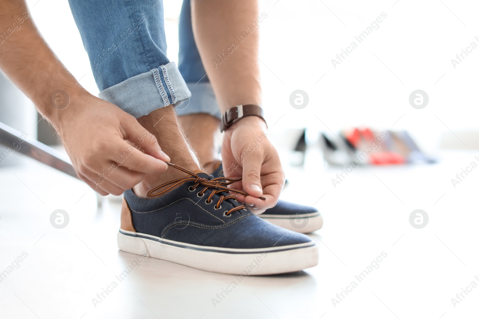 Photo of Young man trying on shoes in store