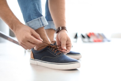 Young man trying on shoes in store