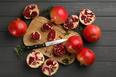 Photo of Delicious ripe pomegranates on grey wooden table, flat lay