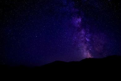 Image of Sky with twinkling stars over mountains at night