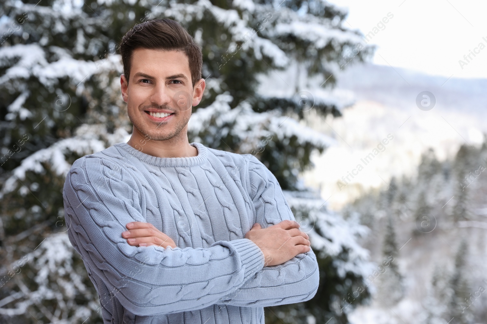 Photo of Happy man wearing warm sweater snowy fir tree