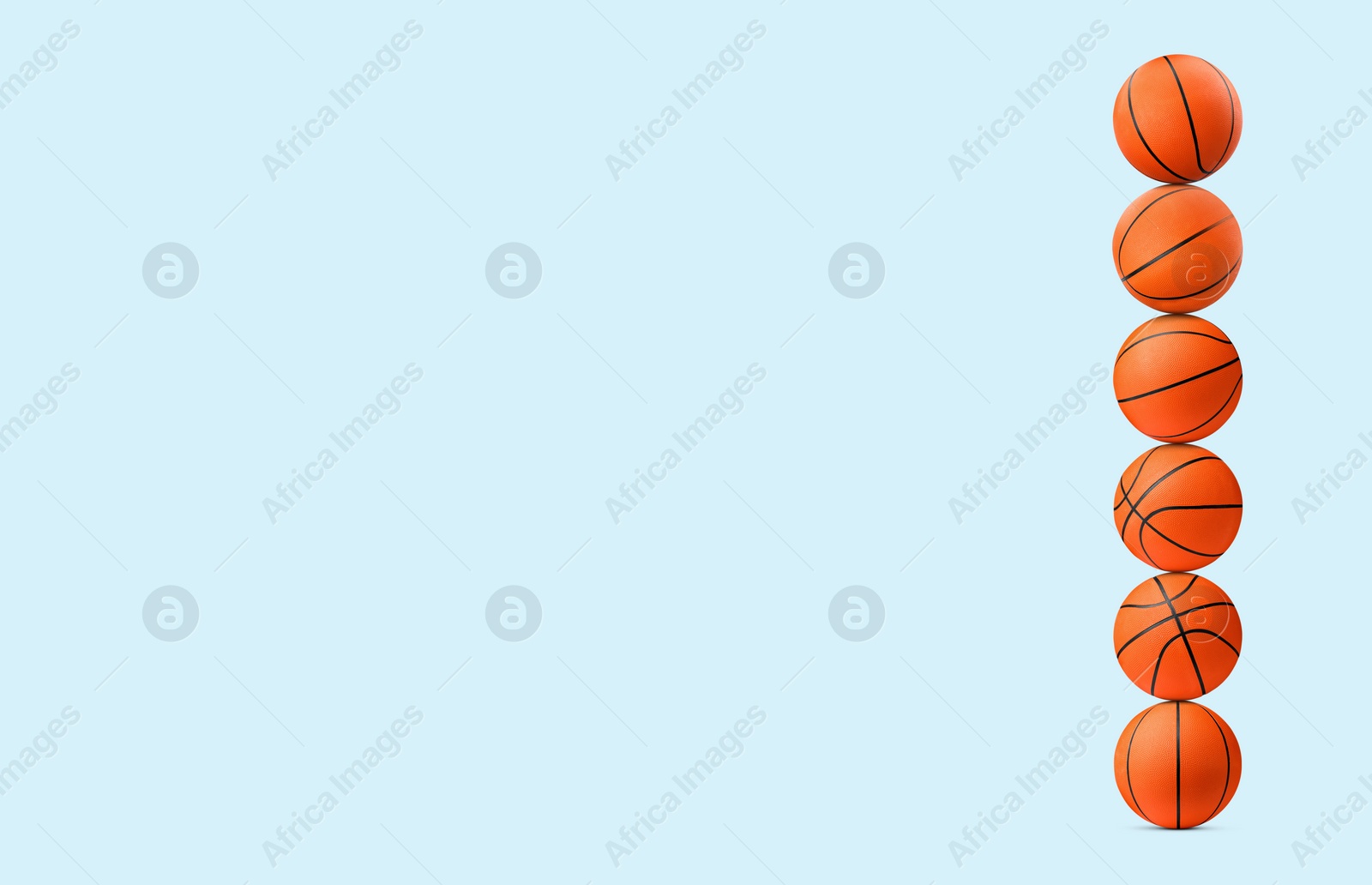 Image of Stack of basketball balls on pale light blue background. Space for text