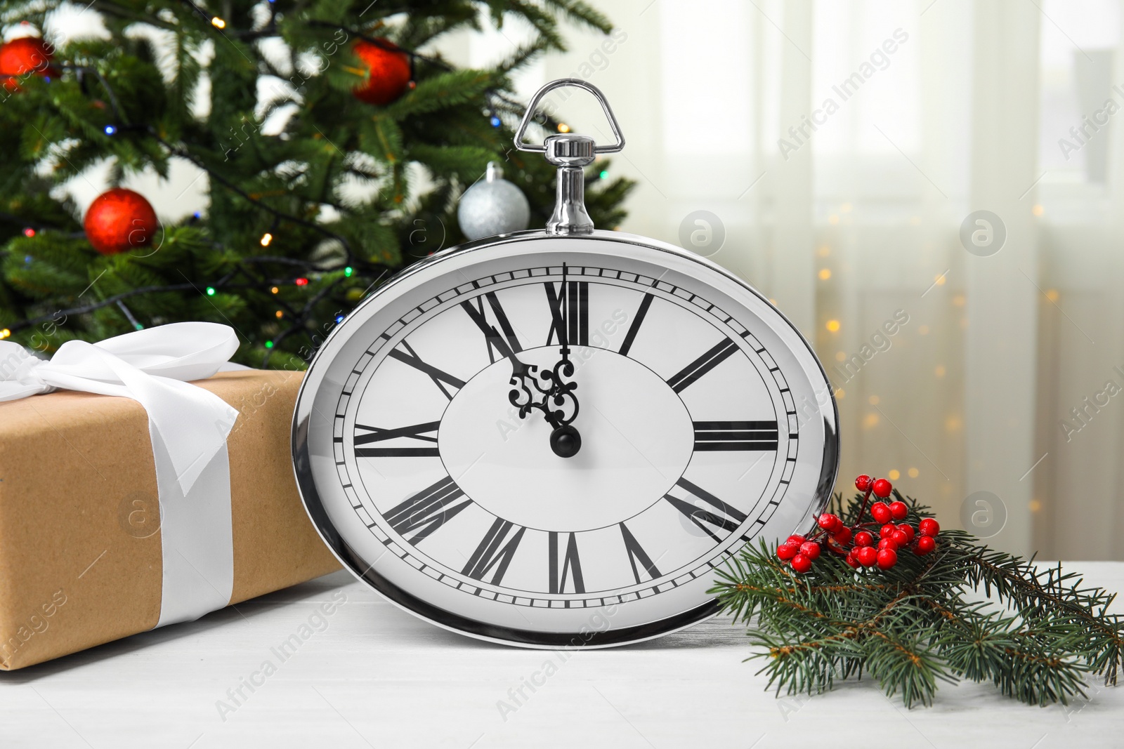 Photo of Clock, gift and festive decor on table. Christmas countdown