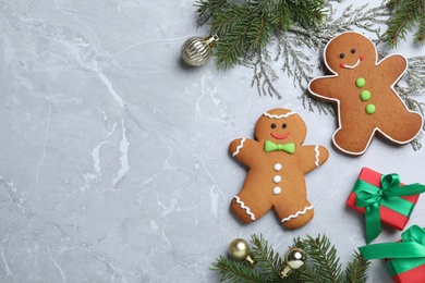 Flat lay composition with gingerbread people on light  grey marble table. Space for text