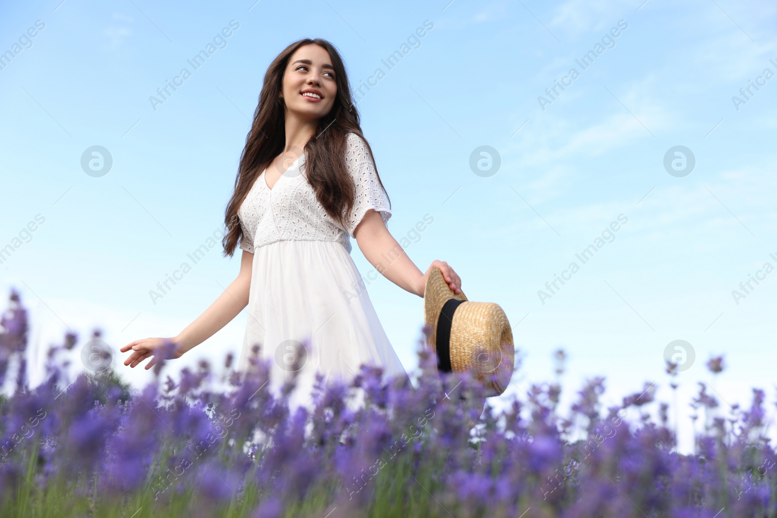 Photo of Young woman with straw hat in lavender field