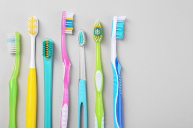 Photo of Many different toothbrushes on light background, flat lay. Space for text