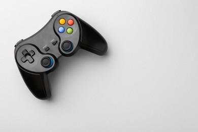 Wireless game controller on light grey background, top view. Space for text