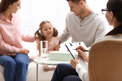 Photo of Professional psychologist working with family in office