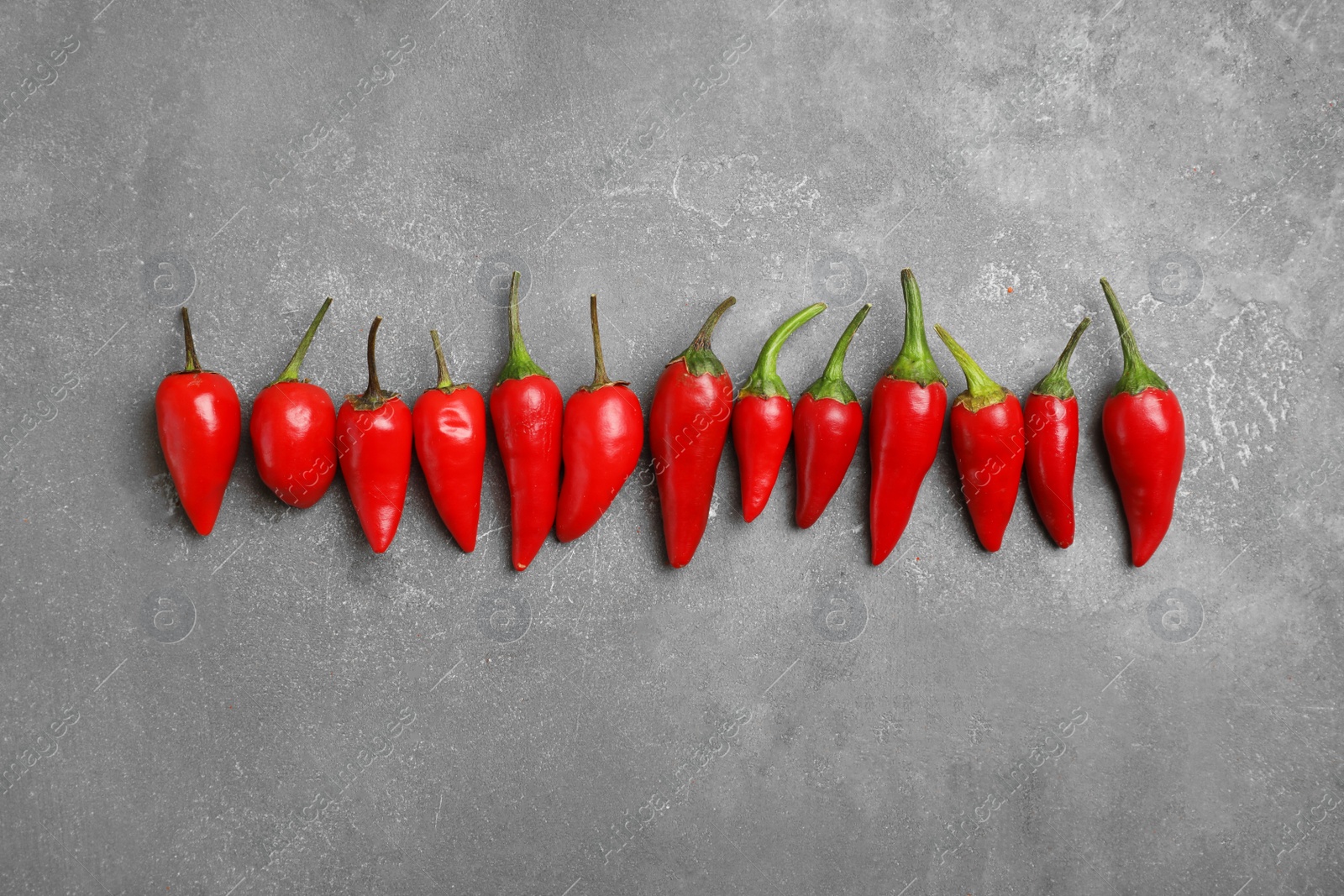 Photo of Flat lay composition with fresh chili peppers on gray background