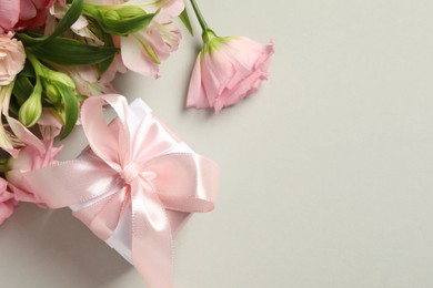 Photo of Happy Mother's Day. Beautiful flowers and gift box on light grey background, flat lay. Space for text