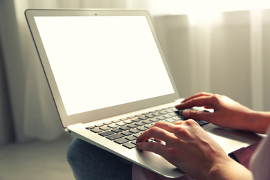 Woman working with modern laptop indoors, closeup