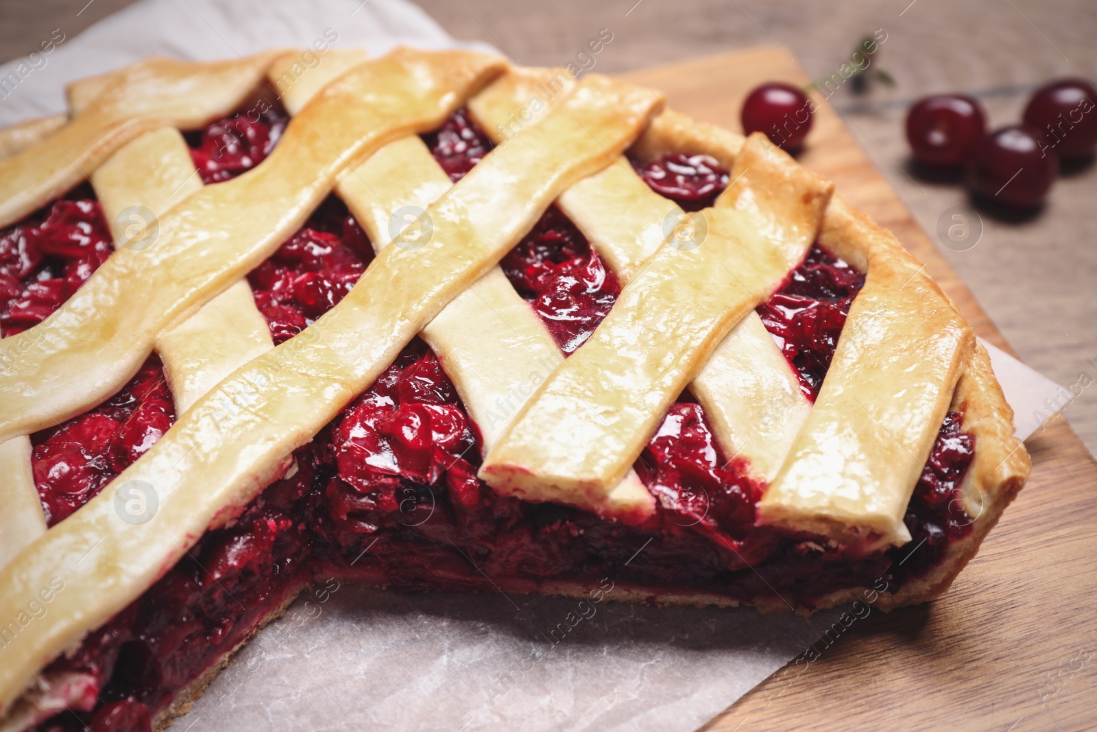 Photo of Delicious fresh cherry pie on wooden board, closeup