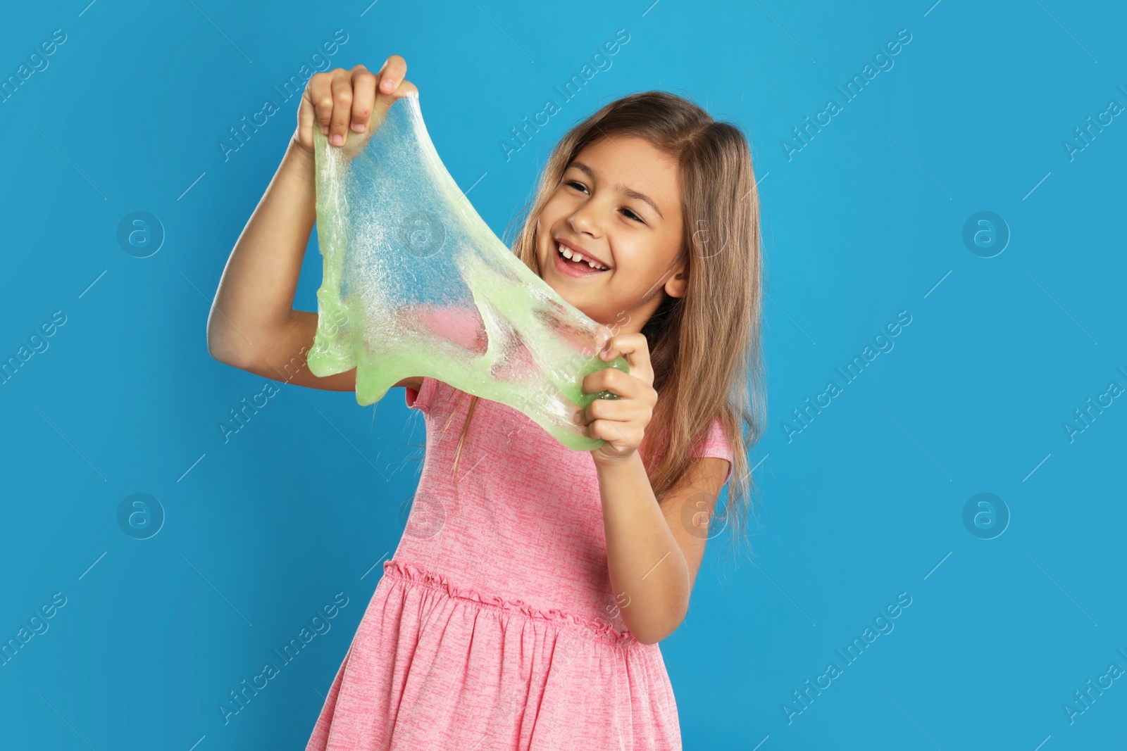 Photo of Little girl with slime on blue background
