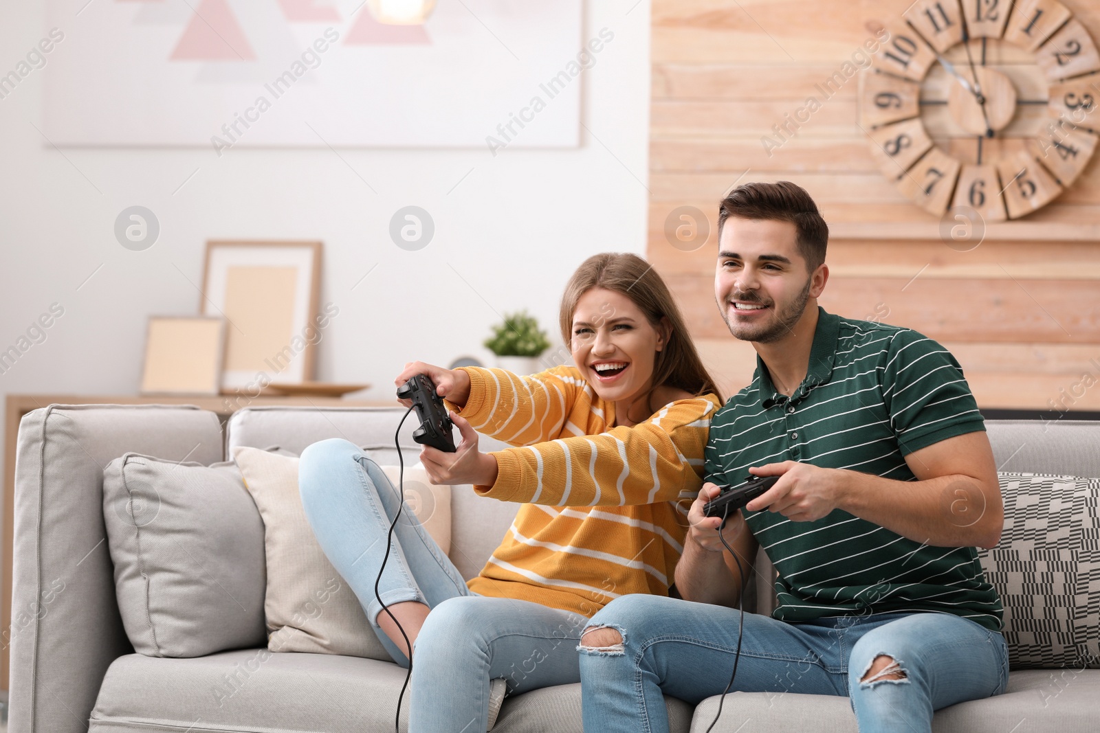 Photo of Emotional young couple playing video games at home