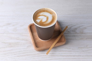 Photo of Coffee to go. Paper cup with tasty drink on white wooden table
