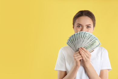 Photo of Young woman with money on yellow background. Space for text