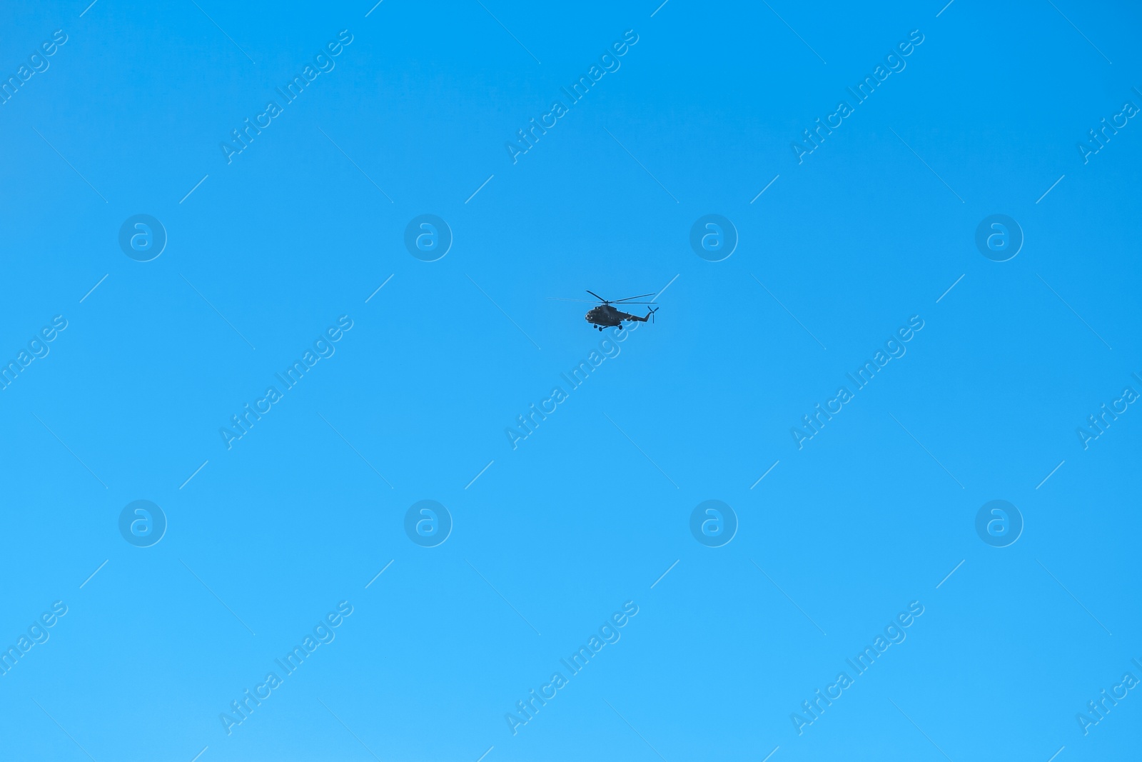 Photo of Modern military helicopter flying in blue sky