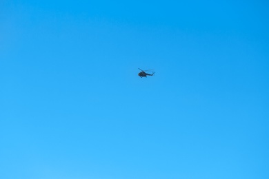 Modern military helicopter flying in blue sky