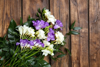 Photo of Beautiful freesia bouquet on wooden background