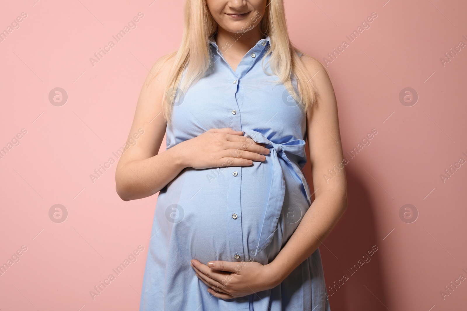 Photo of Pregnant woman in dress on color background