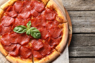 Photo of Tasty pepperoni pizza on wooden table, top view. Space for text