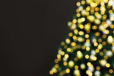 Photo of Blurred view of beautifully decorated Christmas tree on brown background, space for text