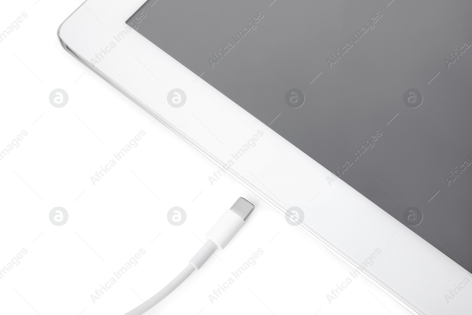 Photo of USB cable with lightning connector and tablet on white background