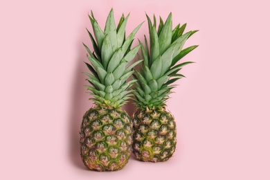 Photo of Whole ripe juicy pineapples on pink background