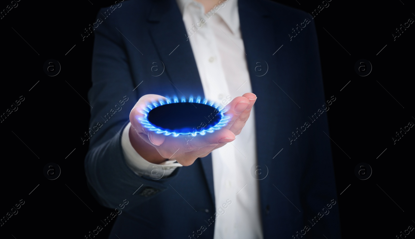 Image of Closeup view of woman holding gas burner with blue flame on black background