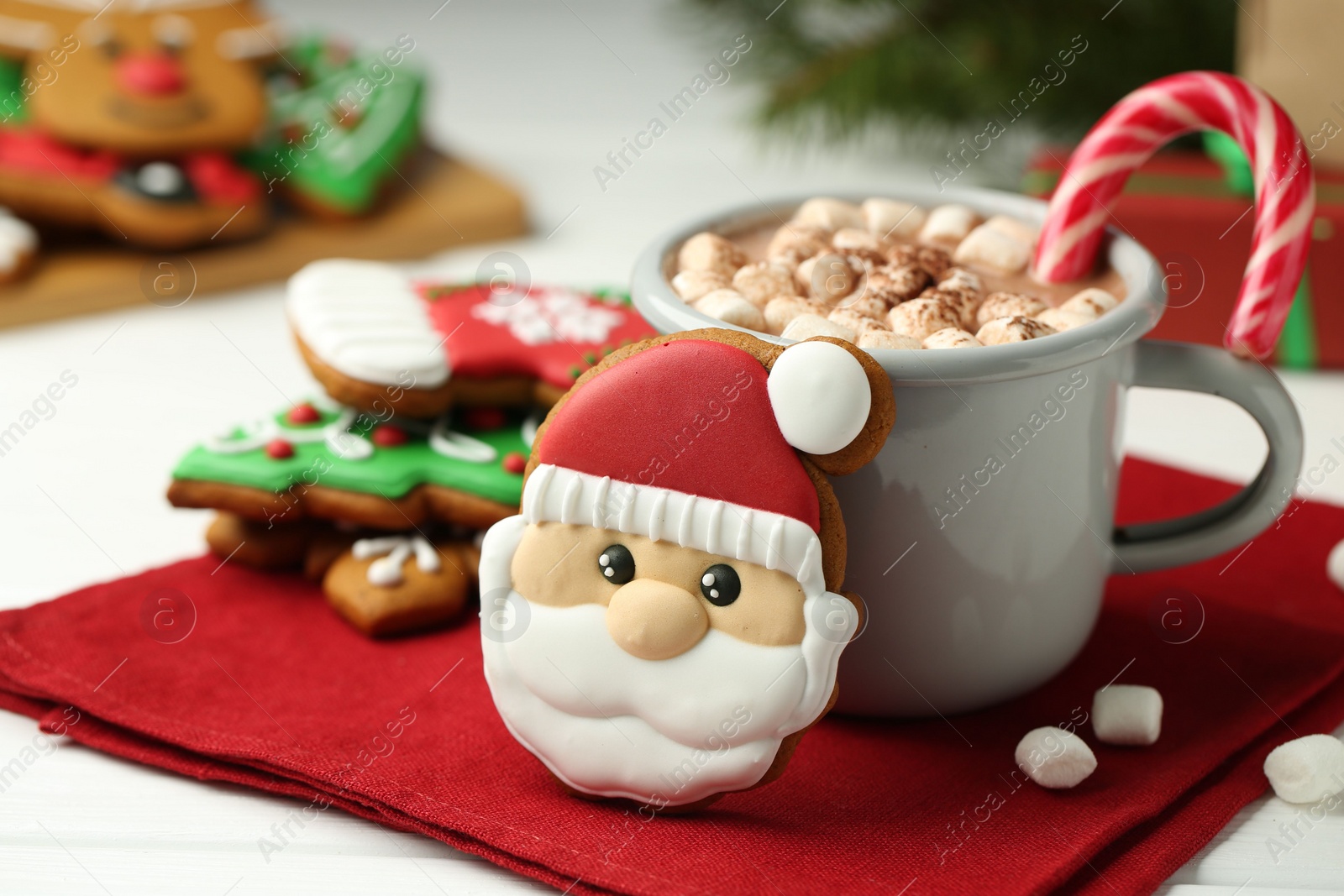 Photo of Tasty homemade Christmas cookie and hot chocolate with marshmallows on white wooden table, closeup