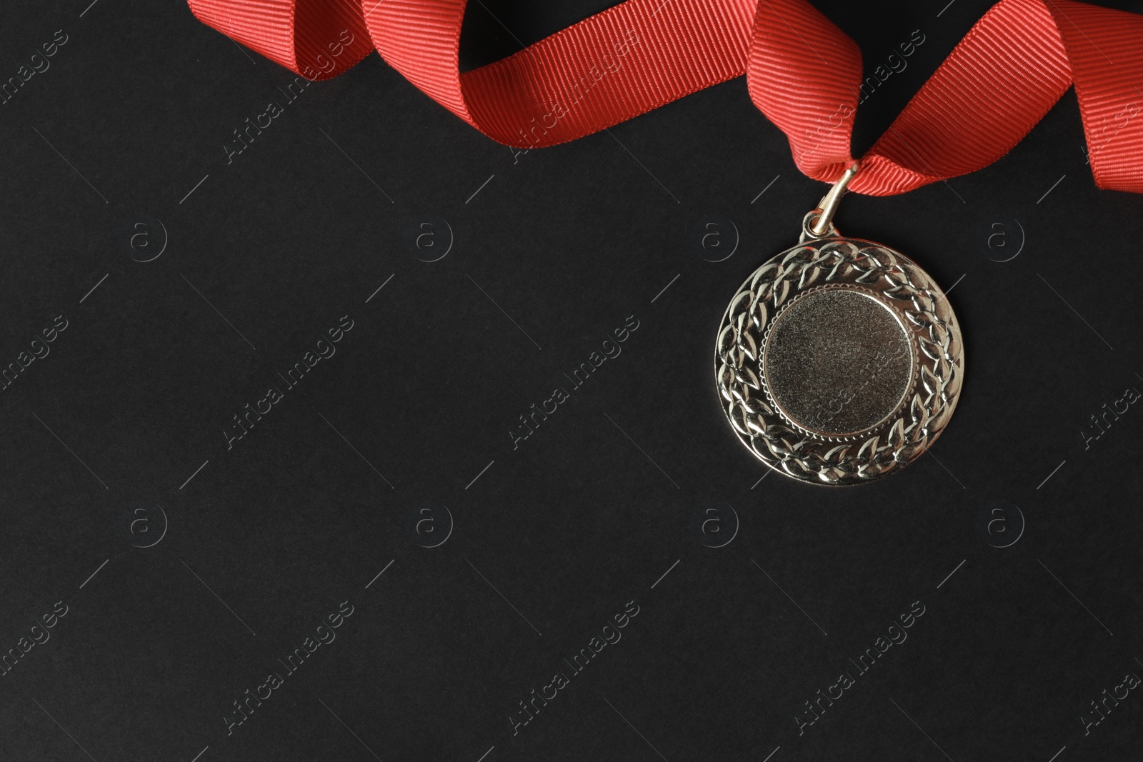 Photo of Gold medal with space for design on black background, top view. Victory concept