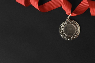 Gold medal with space for design on black background, top view. Victory concept