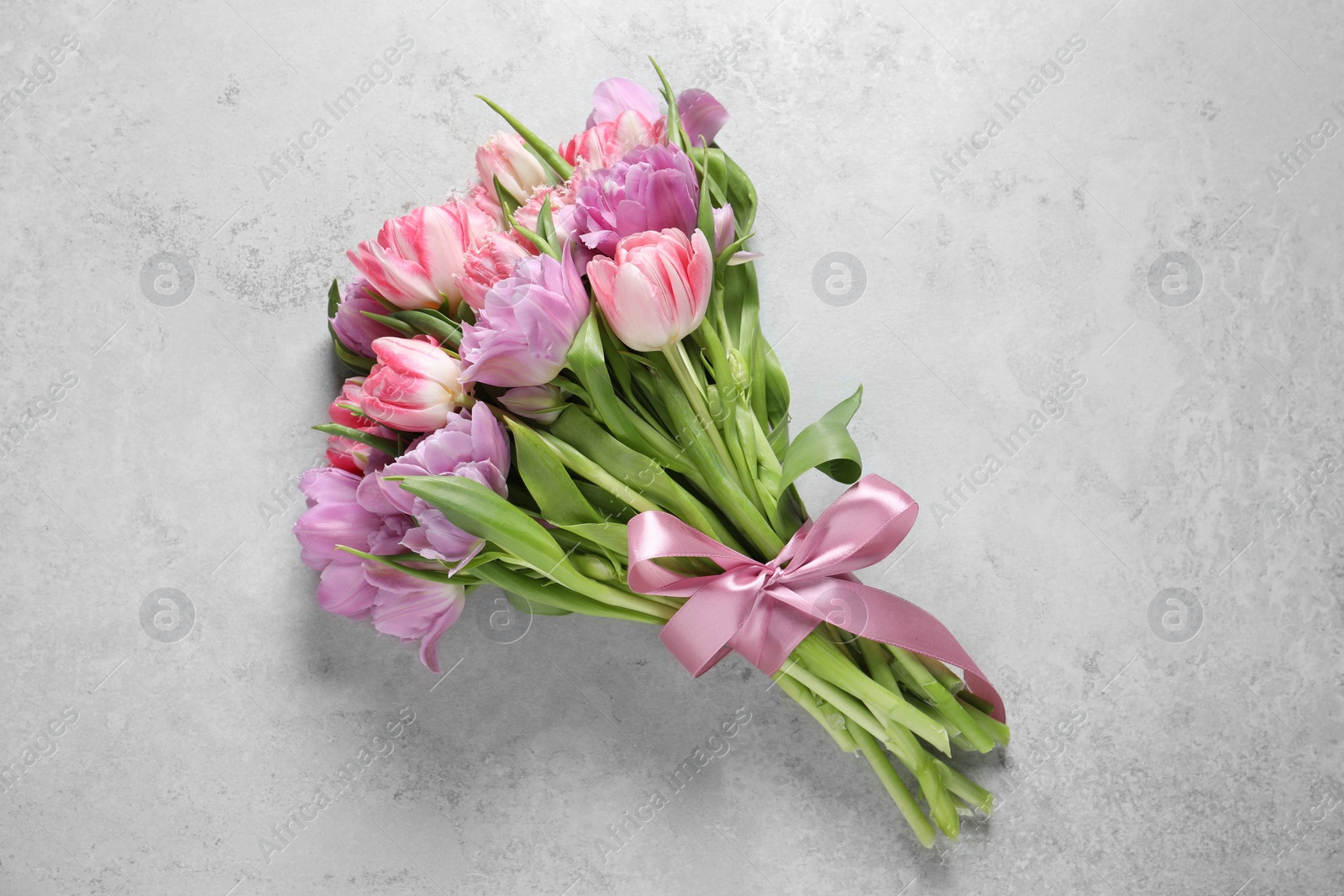 Photo of Beautiful bouquet of colorful tulip flowers on light gray table, top view