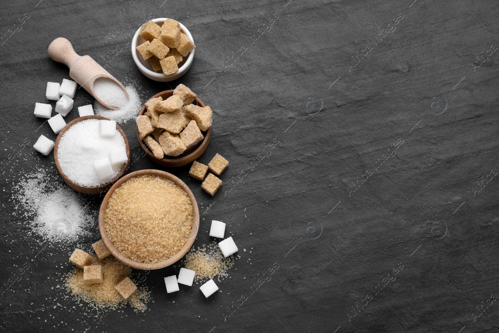 Photo of Different types of sugar on black table, flat lay. Space for text
