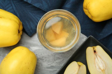 Delicious quince drink and fresh fruits on grey table, flat lay