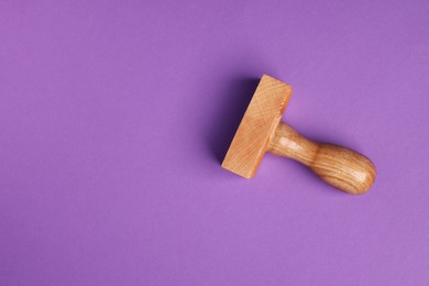 One wooden stamp tool on purple background, top view. Space for text