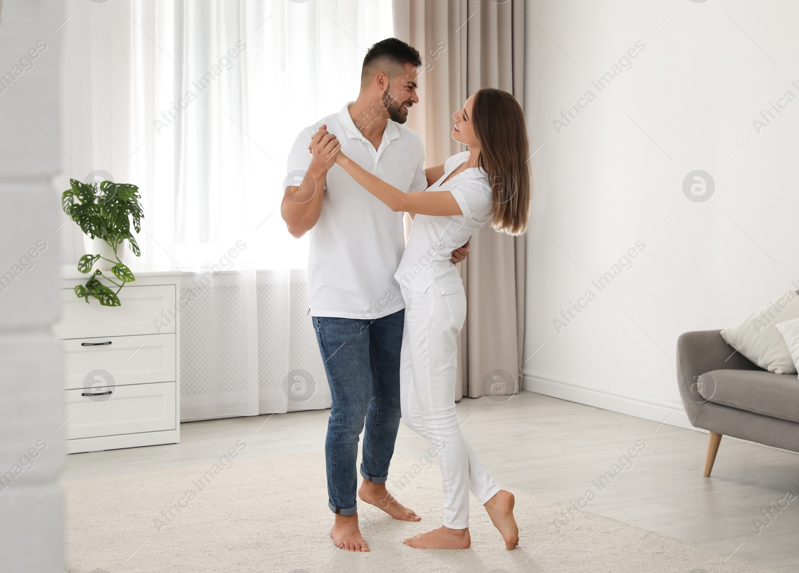 Photo of Lovely young couple dancing together at home