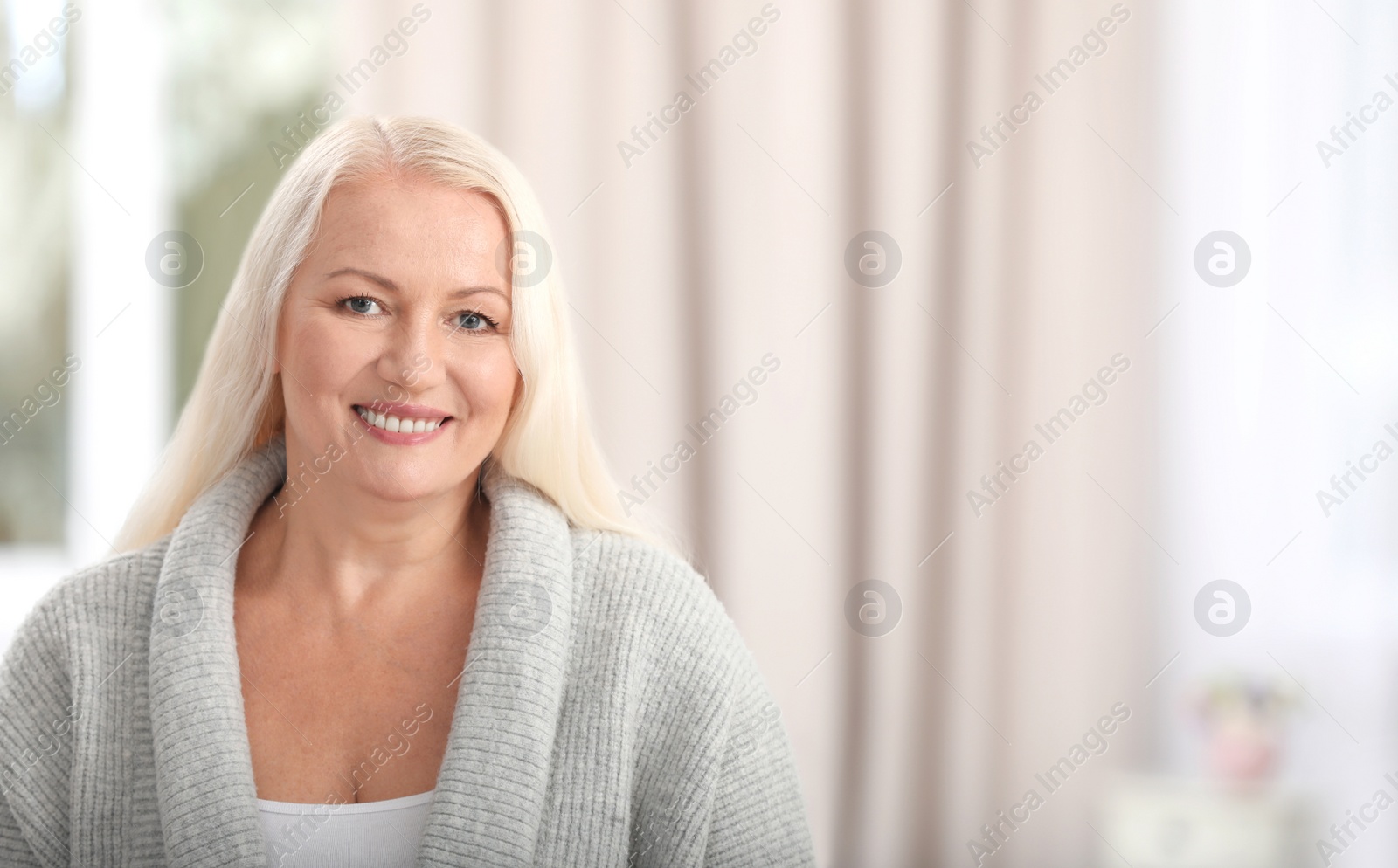 Photo of Portrait of beautiful older woman against blurred background with space for text