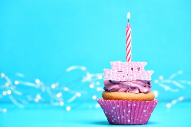 Photo of Birthday cupcake with candle on color background