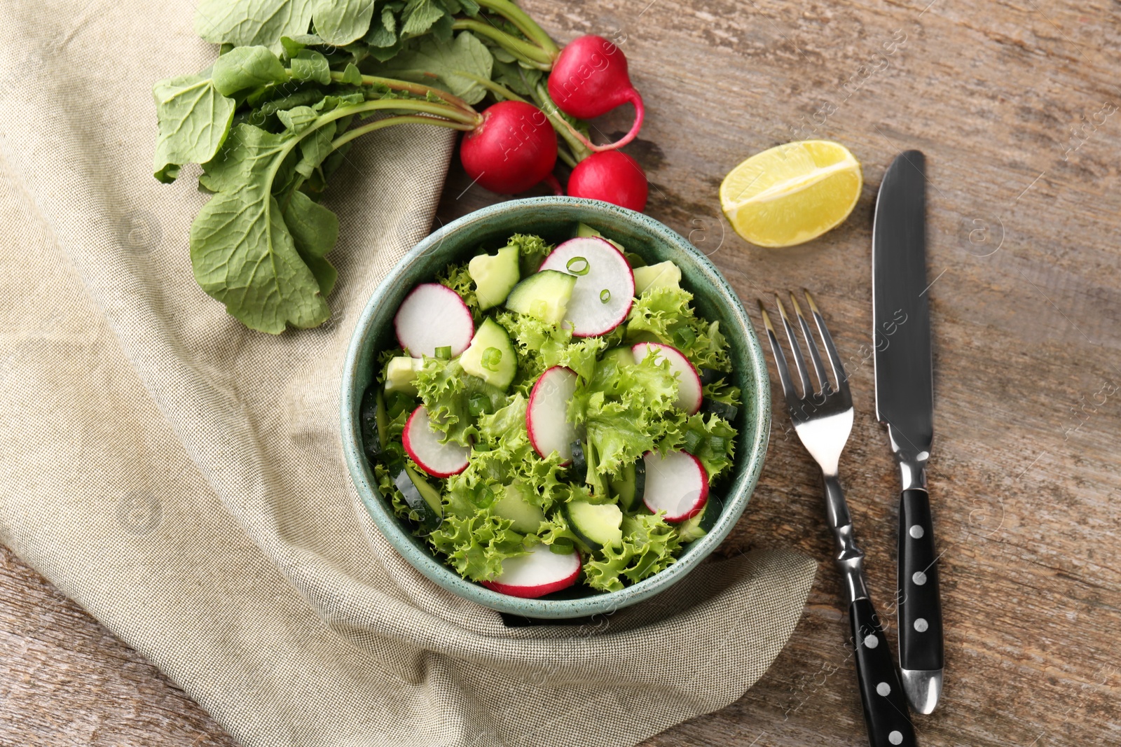 Photo of Delicious salad with radish served on wooden table, flat lay