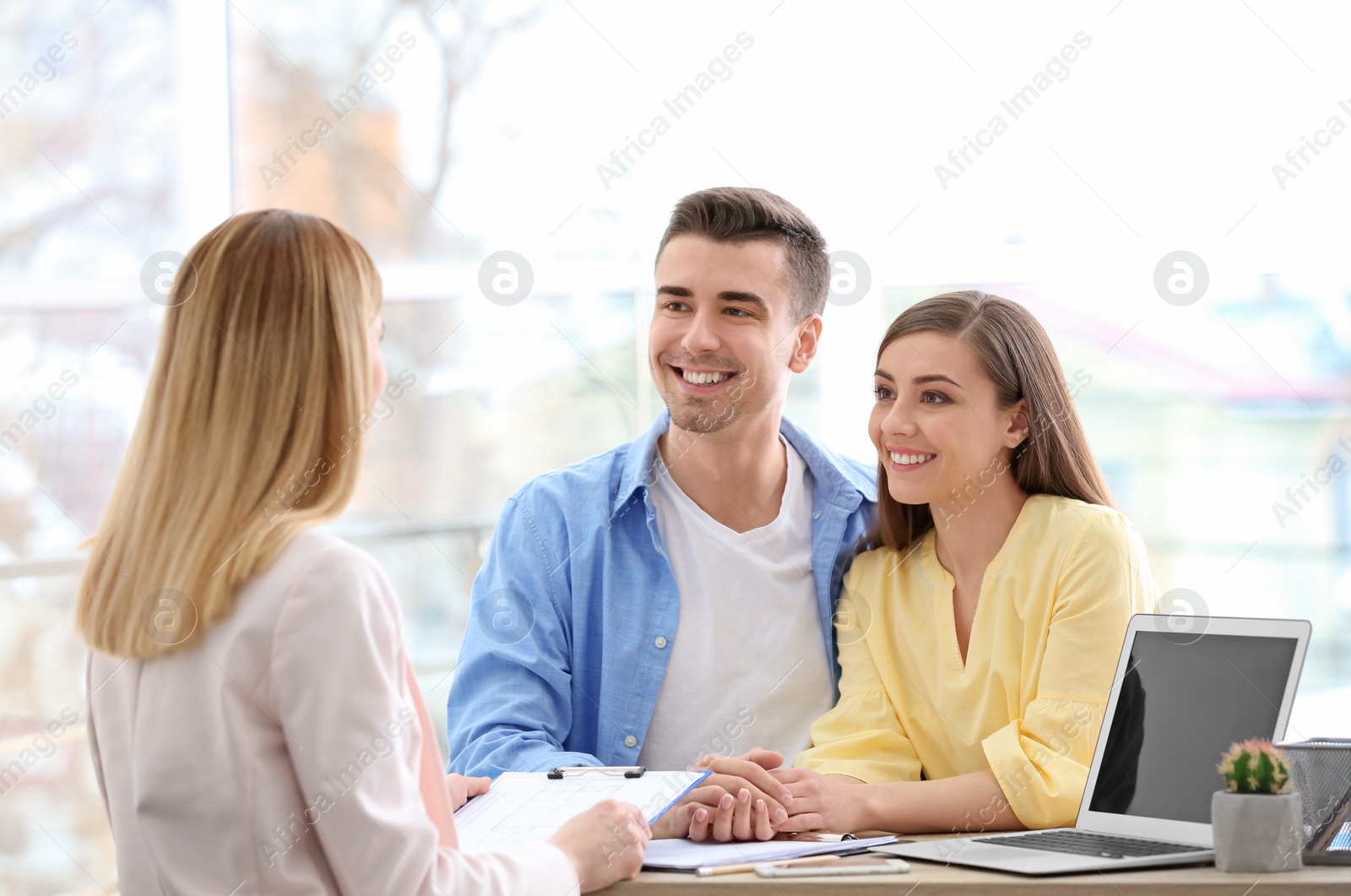 Photo of Young couple meeting with consultant in office