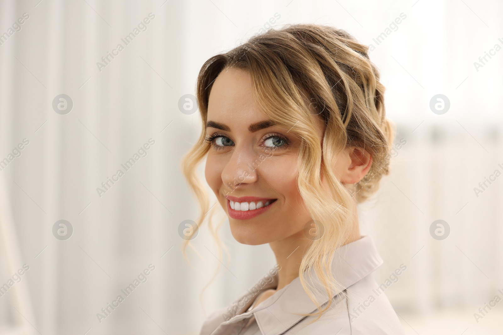 Photo of Portrait of smiling woman with beautiful hair style indoors. Space for text