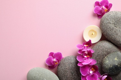 Flat lay composition with spa stones and orchid flowers on pink background. Space for text