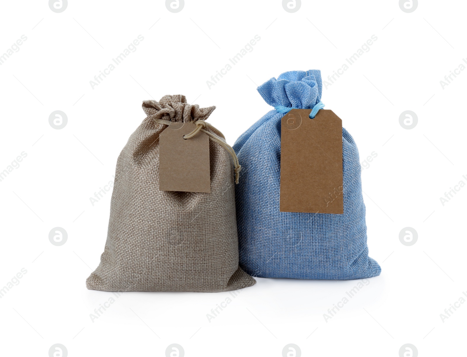 Photo of Tied burlap bags with tags isolated on white