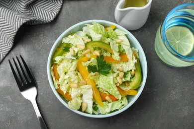 Fresh cabbage salad with bell pepper served on grey table, flat lay