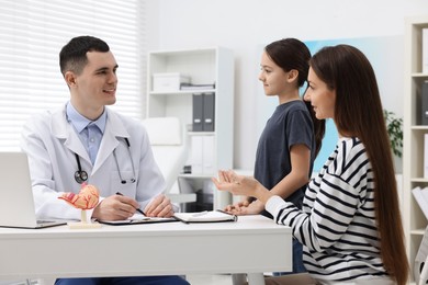 Gastroenterologist consulting woman and her daughter in clinic