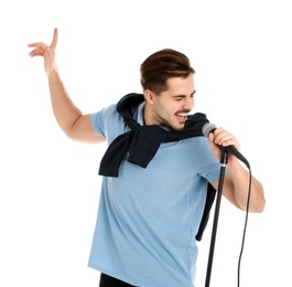 Photo of Young handsome man in casual clothes singing with microphone on white background